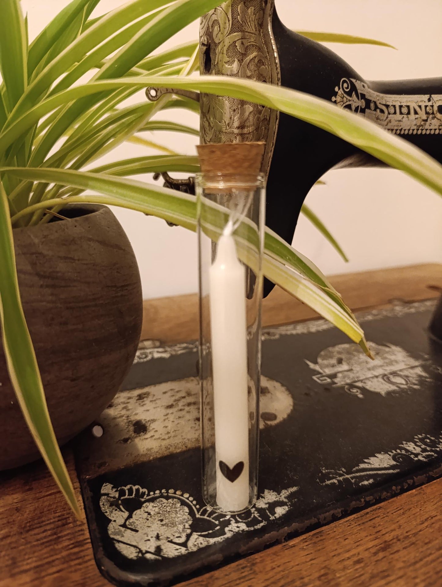 Kaars in glazen buisje met een zwart hartje op